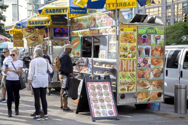 New York, New York / Usa - 11 Ağustos 2019: İnsanlar Kolomb Meydanı 'nı ziyaret ediyor ve bir tanesi bir helal satıcıdan yiyecek alıyor.