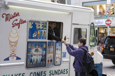 NEW YORK, New York / USA - 7 Mayıs 2018: Genç çocuk kamyon satıcısından dondurma külahı satın aldı.