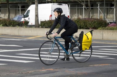 BRONX, NEW YORK / USA - 20 Nisan 2020: Beyaz kadın maske kullanırken bisiklet sürüyor ama Coronavirus salgını sırasında burnunu ve ağzını kapatmıyor. 