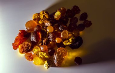 Arka plan aydınlatmalı Baltık kehribar taneleri. Son derece güzel saydam sarı kehribar parçaları. Mücevherler için doğal bir mineral. Güneş taşının renk dokusu.