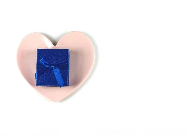 Caja de regalo con un arco, un plato rosa en forma de corazón sobre fondo blanco.Concepto de San Valentín o tema romántico de boda — Foto de Stock
