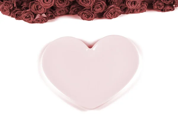 Ajuste de mesa para el Día de San Valentín con hermosas rosas rojas y plato rosa en forma de corazón sobre fondo blanco.Concepto de cena de San Valentín . — Foto de Stock