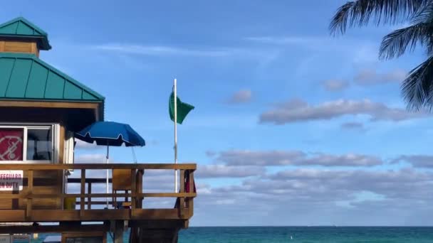 Torre di bagnino con bandiera verde in una luminosa giornata estiva soleggiata, con cielo blu, Oceano Atlantico sullo sfondo. Famosa località di viaggio. Miami, Florida, Stati Uniti d'America . — Video Stock