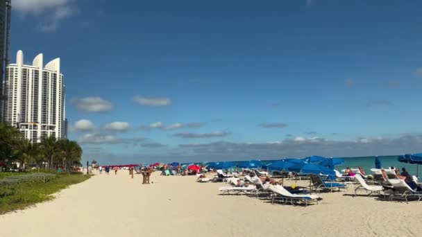 View of Luxury Modern Buildings at sandy beach, οι άνθρωποι απολαμβάνουν την παραλία σε μια ηλιόλουστη μέρα στο Μαϊάμι, ΗΠΑ. — Αρχείο Βίντεο