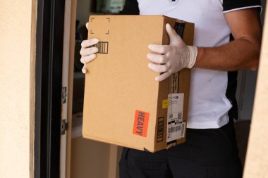 Amazon Prime paketi apartman kapısında. Coronavirus karantinası. Amazon bir çevrimiçi şirket ve dünyanın en büyük perakendecisi..