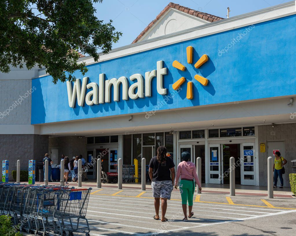 Miami, FL, USA - March 26, 2020: People going in a Walmart store on sunny day. Walmart is the worlds third largest public corporation that runs chains of department stores. Quarantine due Coronavirus