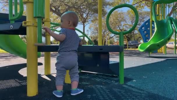 Niedliche Baby-Junge steht unter Spannung auf dem Spielplatz — Stockvideo