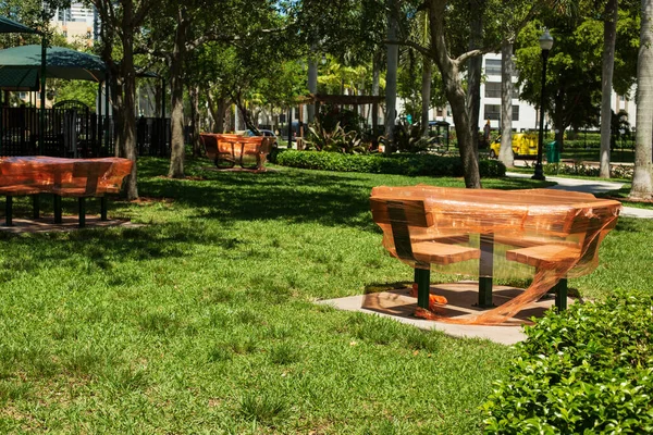 Zona de juegos vacía con mesas cubiertas con película de polietileno naranja y otros equipos en el parque de la ciudad. Espacio para Copiar. Brote de Coronavirus. Quédate en casa. — Foto de Stock