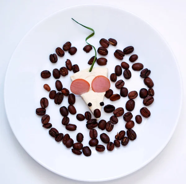 Food art idea for breakfast or lunch. Funny mouse from coffee, sausage, cheese on the white plate. Funny food.