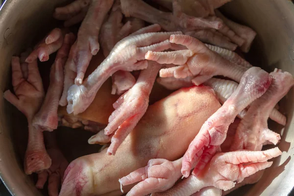 Trotes de porco e pernas de frango em uma panela para cozinhar — Fotografia de Stock