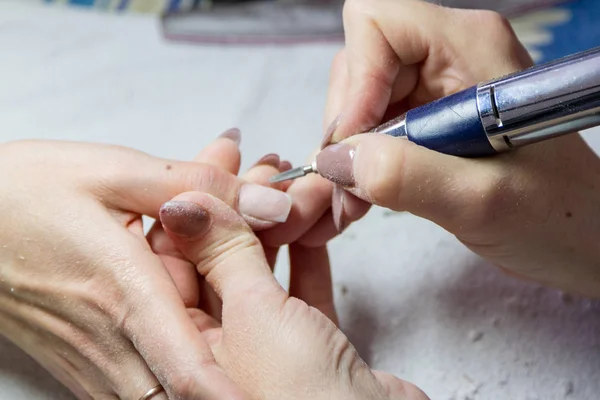 El tratamiento de la extensión de las uñas en el salón de belleza por la herramienta especial — Foto de Stock