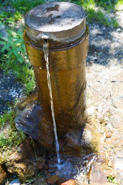 Eski ve paslı bir borunun içinde bir delikten su