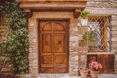 stará budova s dřevěnými dveřmi a hrnkové rostliny na ulici v Castel Gandolfo, předměstí Řím, Itálie 