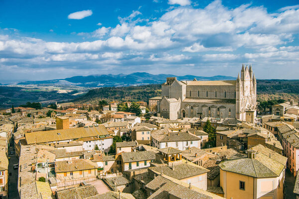 aerial view of Orvieto Cathedral and buildings with mountains on background in Orvieto, Rome suburb, Italy 