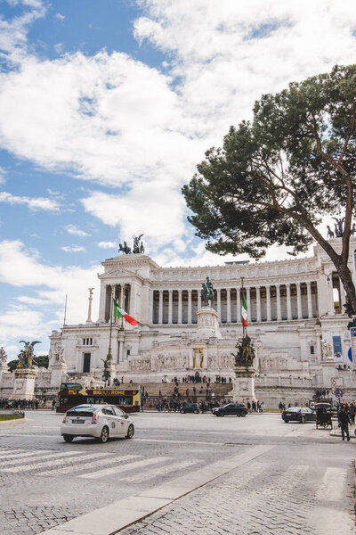 ROME, ITALY - 10 MARCH 2018: beautiful ancient building of Altare della Patria with cars and people on Piazza Venezia (Venezia Square)