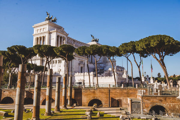 roman forum ruins with Altare della Patria (Altar of the Fatherland) building on background, Rome, Italy