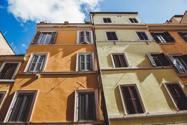 bottom view of old buildings on street of Rome on sunny day, Italy