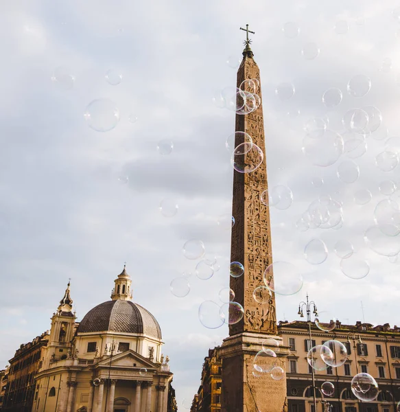 obelisk at piazza del popolo (peoples square) and soap bubbles in Rome, Italy