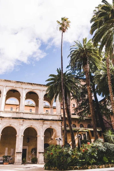 Красивый старинный атриум с пальмами на переднем плане, Рим, Италия — стоковое фото