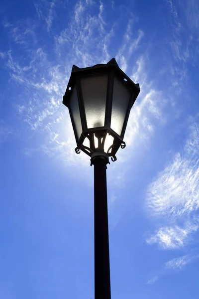 Lantaarnpaal in achtergrondverlichting op sky — Stockfoto