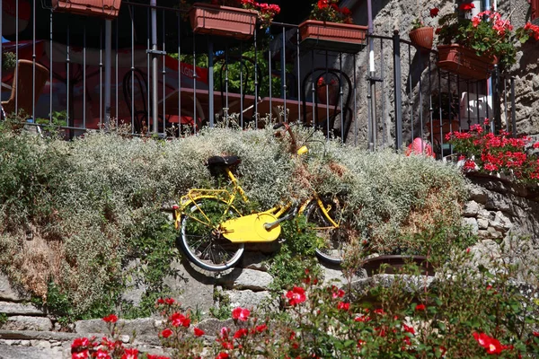 Bicicleta amarela na parede san marino — Fotografia de Stock