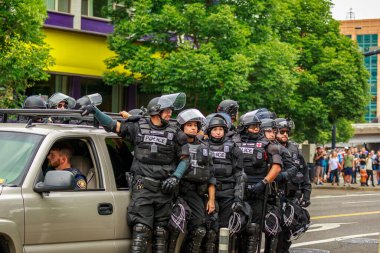 Portland, Oregon - August 17 2019: Portland police rapid response team in anti-riot gear and uniforms, riding car in downtown