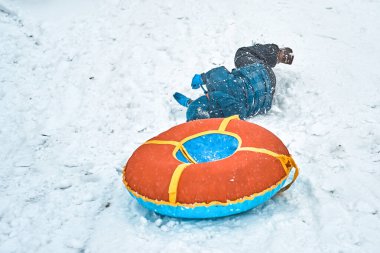 Küçük çocuk kışın kızak borusundan düştü.