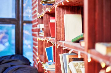 Pencere arkaplanında kitaplar olan kitaplık