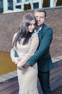 Güzel kız ve erkek kucaklaşır. Gece elbiseli bir kadın ve takım elbiseli bir adam.