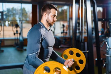 Sporcu çocuk halterle antrenman yapıyor. Spor salonunda ağırlık yapan atletik bir adam.