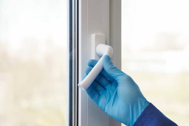 Odayı havalandırıyorum. Lastik eldivenli eller Pencereyi açın