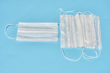 Mavi arka planda beyaz tıbbi maskeler