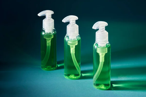 three plastic bottle sanitizer green. blue background