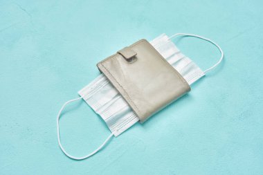 Koruyucu maske ve deri cüzdan. para hastalığı ve ekonomi virüsü kavramı
