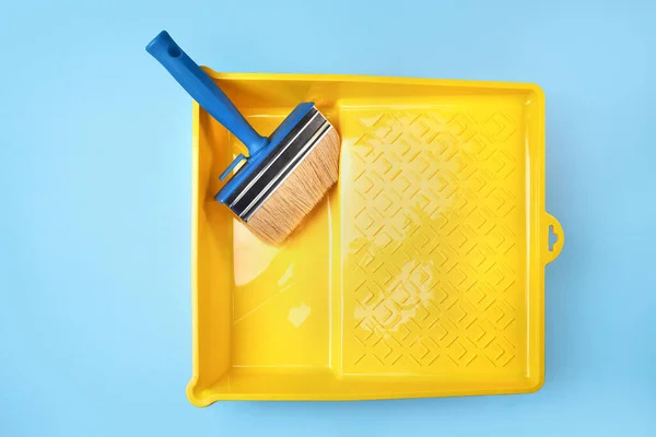 plastic yellow bath with brushes and a roller for painting and repair. blue background