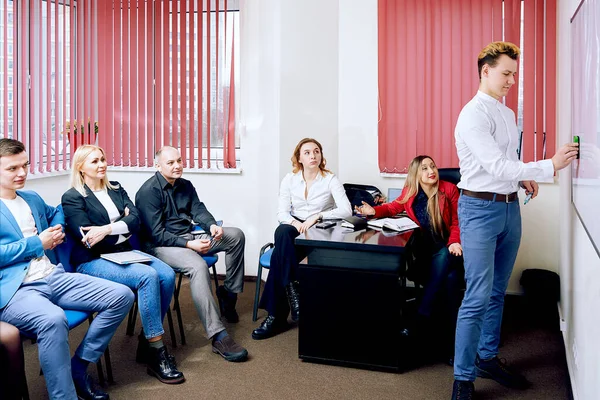 large team in the office works. managers have a discussion near the board.