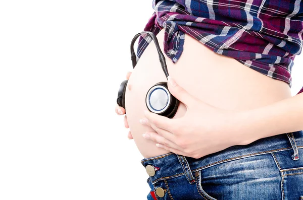 ヘッドフォンで妊娠中の腹 — ストック写真