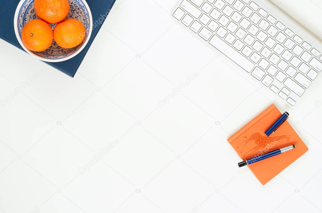Minimal elegant desk with tangerines and keyboard