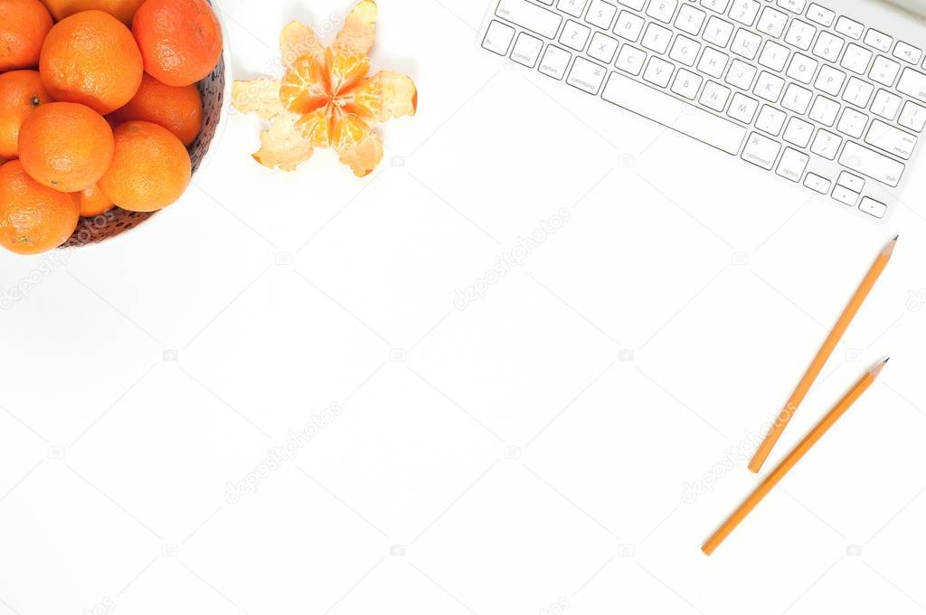 Minimal elegant desk with tangerines and keyboard