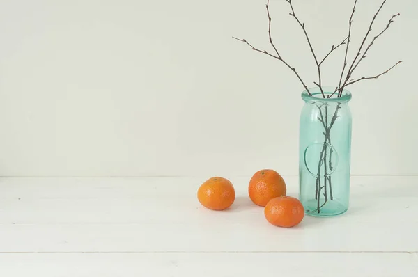 Мінімальна елегантна композиція з мандаринами та вазою — стокове фото