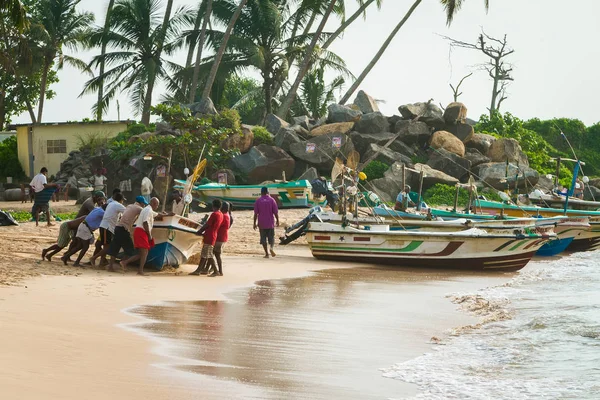 Pescadores en una playa tropical empujan el barco, Sri Lanka — Foto de Stock