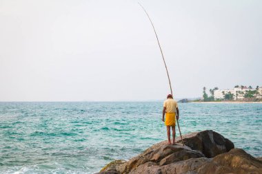 Tropik sahilde balık balıkçı yakalar