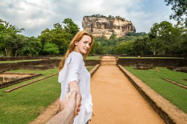 Sigiriya, Sri Lanka. Girl leads (follow me) by the hand to the r clipart