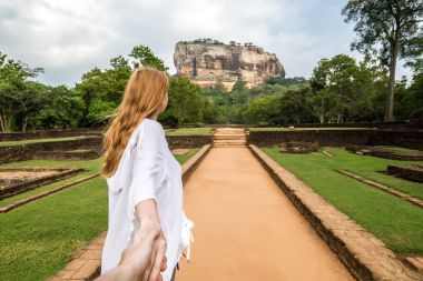 Sigiriya, Sri Lanka. Girl leads (follow me) by the hand to the r clipart