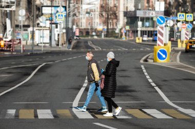 Covid-19, Moskova 'da karantina, Rusya' da koronavirüs. Koruyucu tıbbi maskeli insanlar kendilerini izole ettikleri sırada karşıdan karşıya geçerler..