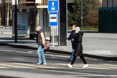 Covid-19, Moskova 'da karantina, Rusya' da koronavirüs. Koruyucu tıbbi maskeli insanlar kendilerini izole ettikleri sırada karşıdan karşıya geçerler..