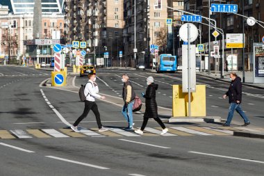Covid-19, Moskova 'da karantina, Rusya' da koronavirüs. Koruyucu tıbbi maskeli insanlar kendilerini izole ettikleri sırada karşıdan karşıya geçerler..