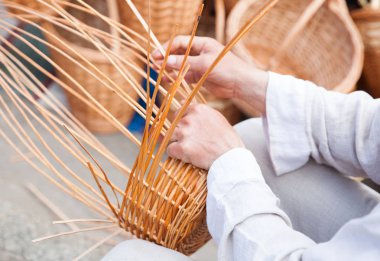 Adamın elleri bir hasır sepet yapım