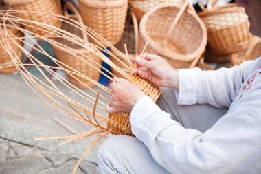 Adamın elleri bir hasır sepet yapım