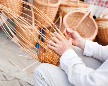 Adamın elleri bir hasır sepet yapım